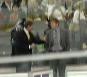 Gretzky with the yellow tie talking to his asst Ulf Samuelsson